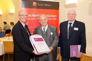 LexisNexis-Geschftsfhrer Mag. Peter Davies bergibt dem Jubilar Professor Rill zum 80. Geburtstag eine ZfV-Torte.